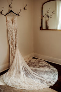 Wedding photography, a dress hangs on the wall for the bride to be in a dressing room